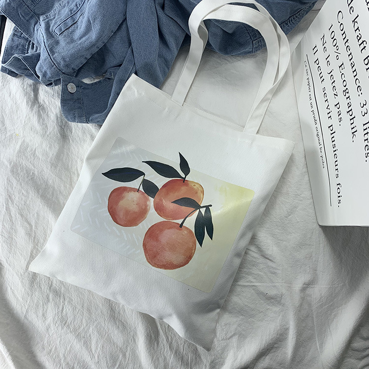 アップルのイラスト入りの白い鞄