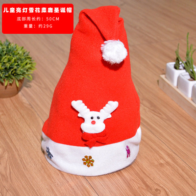子供が明かりをともす雪のシフォンのクリスマス帽